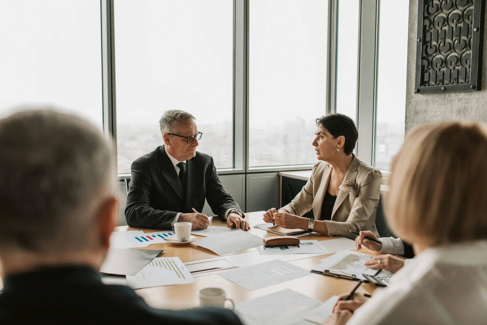 Board members in a meeting discussing a leadership transition plan